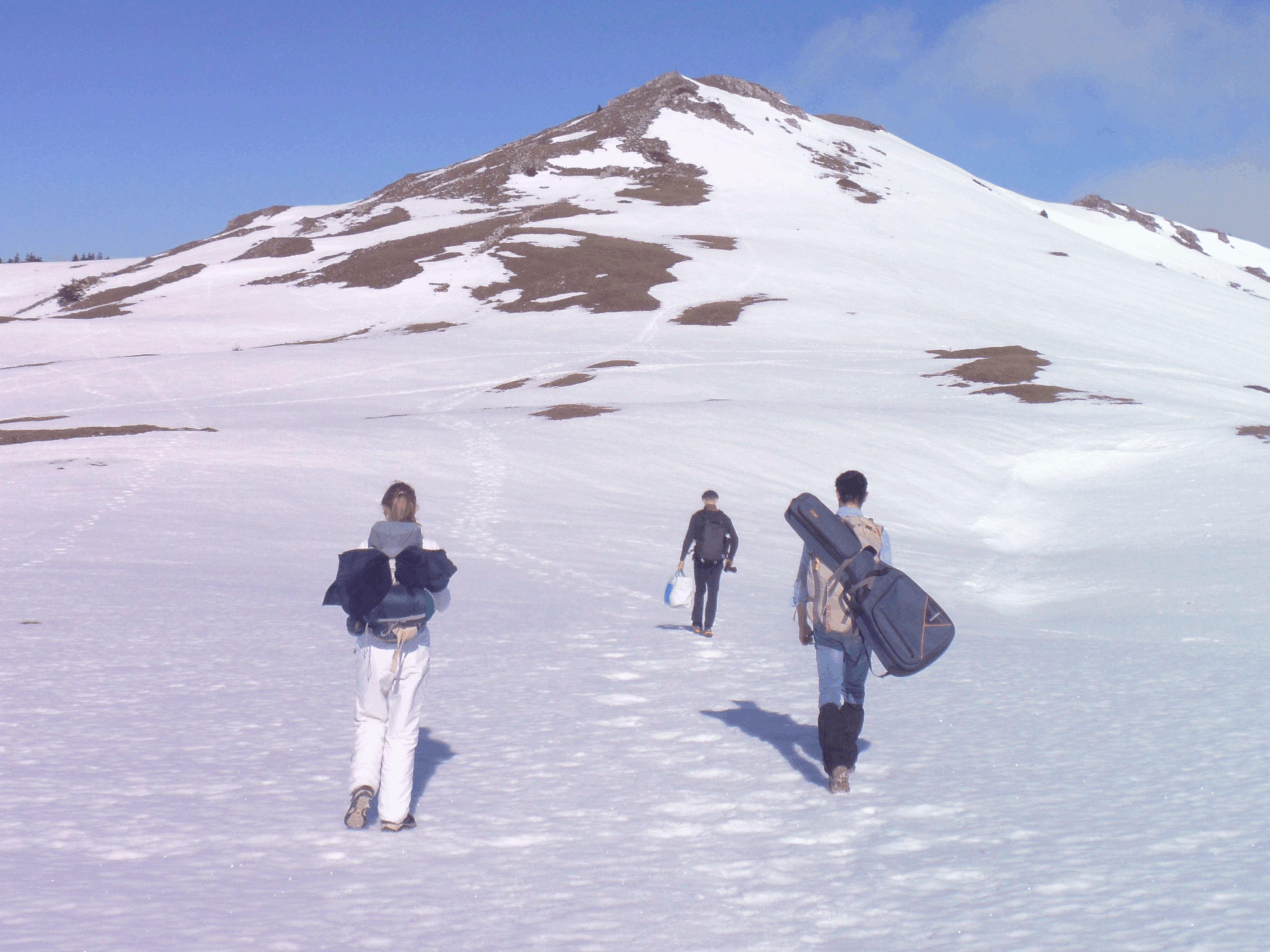 Randonneurs dans la neige vers un sommet du Jura